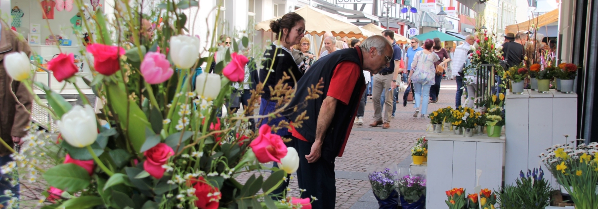 Besucher der Frühlingsmesse flanieren in der mit bunten Blumen geschmückten Fußgängerzone in Bad Honnef